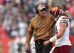 Washington Commanders quarterback Sam Howell and head coach Ron Rivera talking on the sidelines